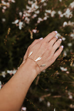 Joli bracelet fin et délicat, il est orné de jolies perles transparentes et de 3 feuilles sculptées suspendue à la chaine.